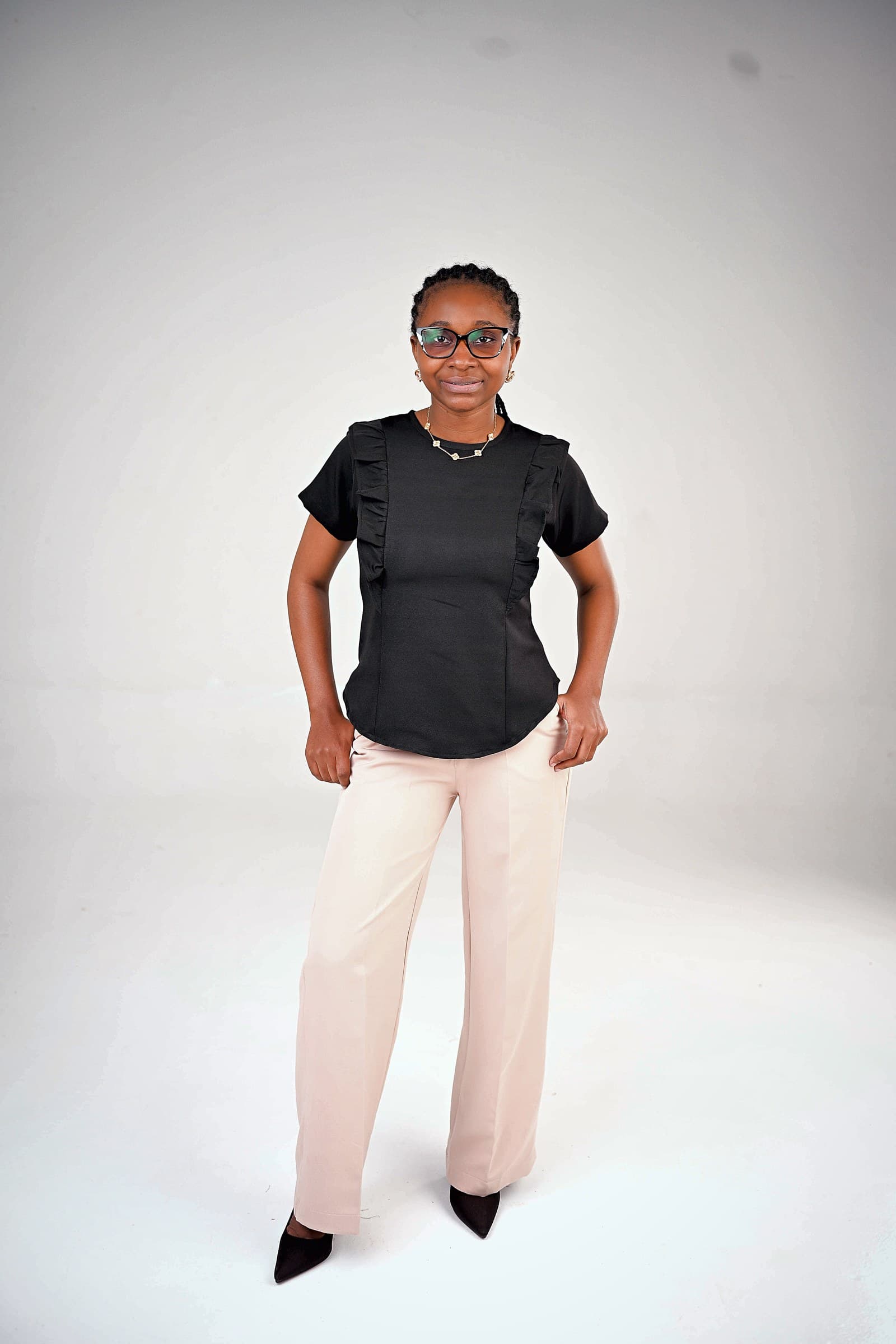 Black ruffle top with blush wide-leg trousers