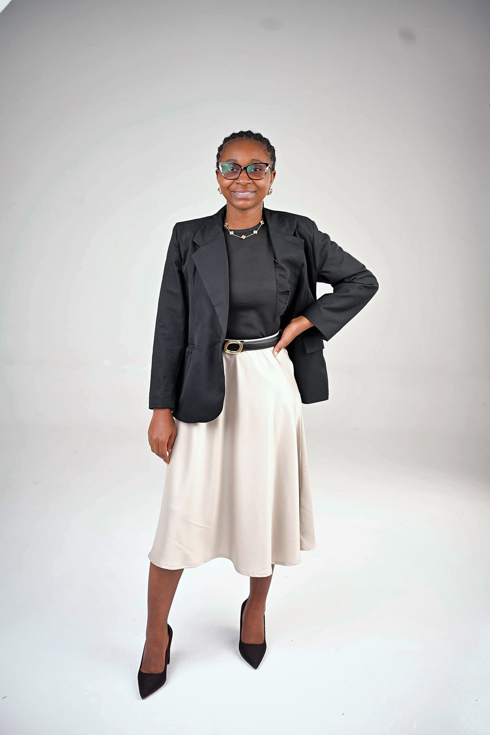 Black blazer over black top and cream midi skirt