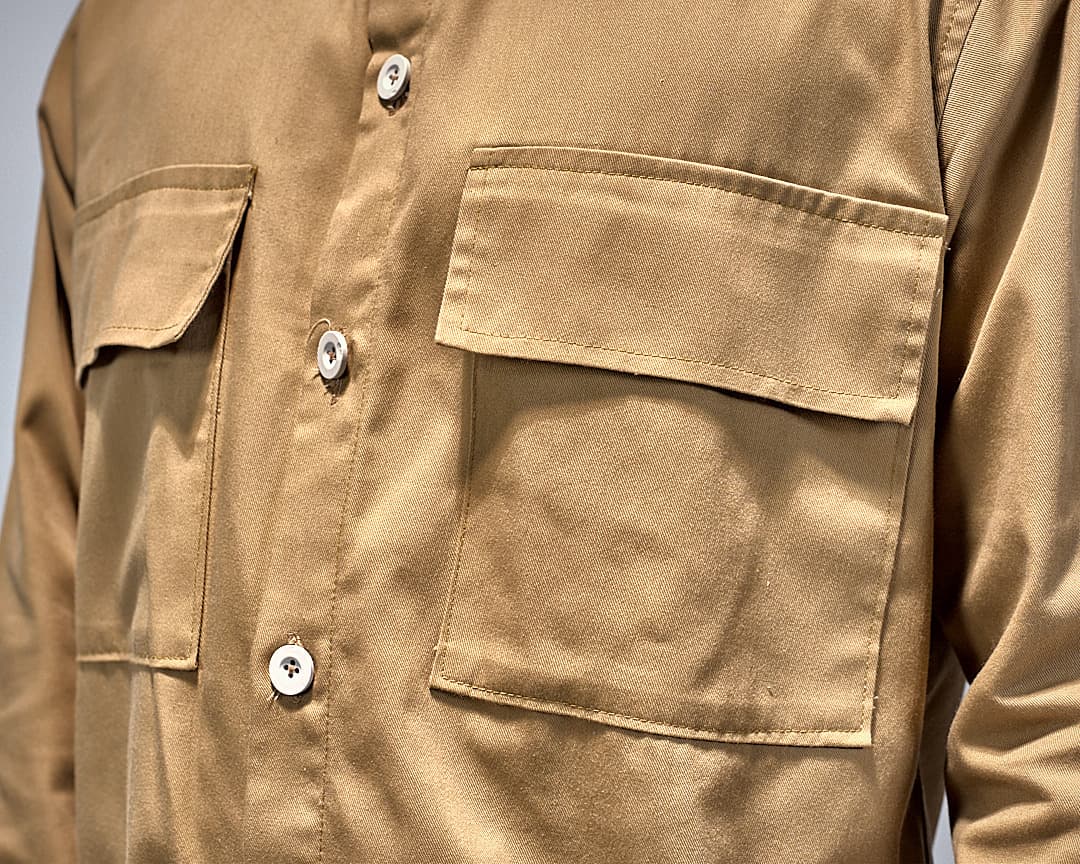 Close detail of the sand overshirt: chest pockets, buttons and topstitching