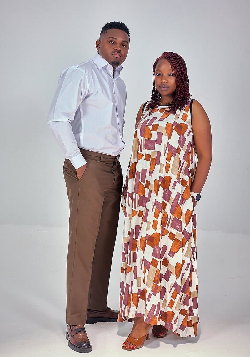 White shirt and brown trousers beside a print maxi dress